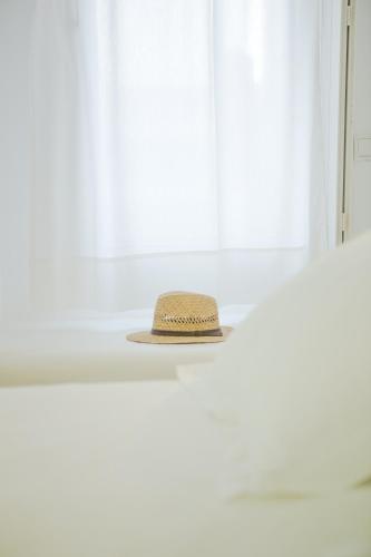 a straw hat sitting on a window sill at Agnandi Cielo in Tourlos