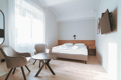 a bedroom with a bed and a table and chairs at Pokoje Venezia in Cieszyn