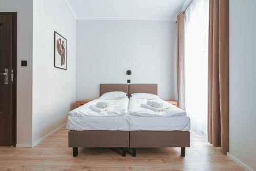 a bedroom with a bed and a large window at Pokoje Venezia in Cieszyn