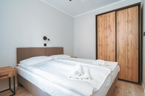 a bedroom with a bed with white towels on it at Pokoje Venezia in Cieszyn