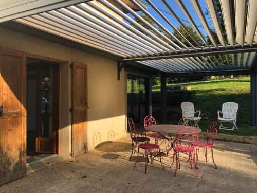 a patio with a table and chairs under a pergola at Havre de paix et de verdure proche Walibi et A43 - 4 étoiles in Corbelin