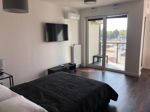 1 dormitorio con 1 cama y TV en la pared en Apartamenty Platinex 5 en Cracovia