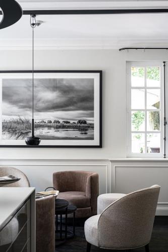 a living room with chairs and a picture on the wall at La Butte aux Bois a Small Luxury Hotel of the World in Lanaken