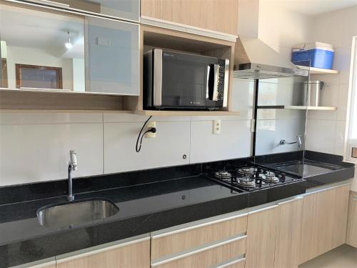 uma cozinha com um lavatório e um micro-ondas em Apartamento Tambau a Beira Mar em João Pessoa