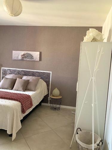 - une chambre dotée d'un lit avec un cadre blanc dans l'établissement Haut de villa entre mer et campagne, à Hyères