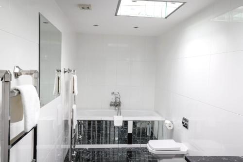 a white bathroom with a sink and a toilet at Suncliff Hotel - OCEANA COLLECTION in Bournemouth