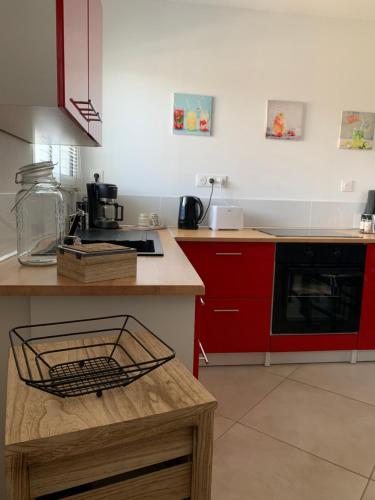 une cuisine avec des armoires rouges et un comptoir dans l'établissement Haut de villa entre mer et campagne, à Hyères