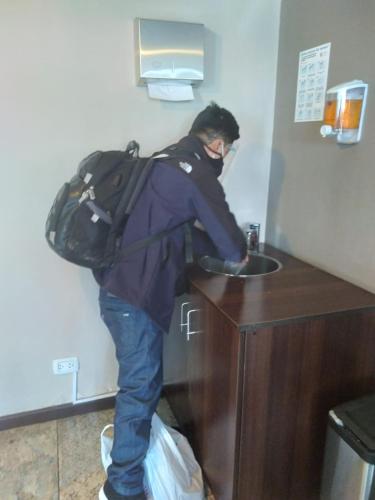 a man with a backpack standing at a sink at Samana Hotel in Arequipa