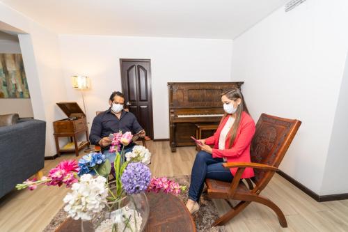a man and woman wearing face masks in a living room at Samana Hotel in Arequipa