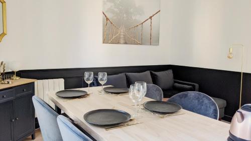 - une table avec des assiettes, des verres à vin et un pont dans l'établissement Rêves Paisibles Onyx - Choisy, à Choisy-le-Roi