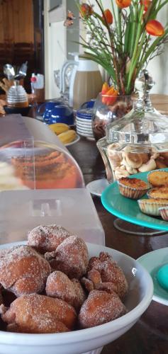 een tafel met een bord donuts en gebak bij Pousada Três Coqueiros in Praia do Bananal