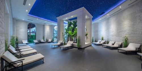 a lobby with white lounge chairs and plants at Granada Luxury Belek - Family Kids Concept in Belek