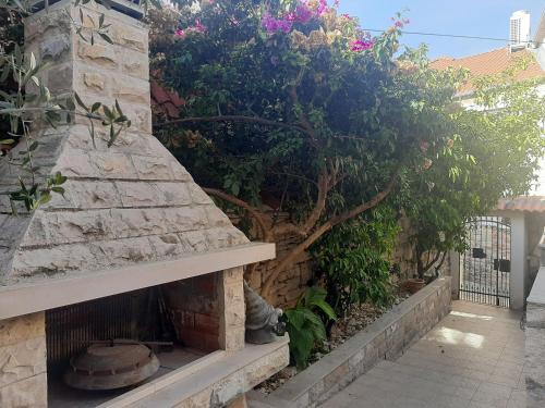 a cat sitting next to a stone wall with a fireplace at Vila Dora Supetar in Supetar