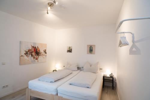 2 Betten in einem Zimmer mit weißen Wänden in der Unterkunft FeWo Engler Lauenburg Bahnhofstraße in Lauenburg