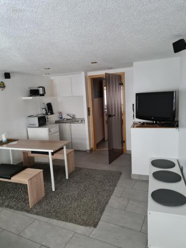 a living room with a table and a kitchen at FeWo Iris in Alsfeld