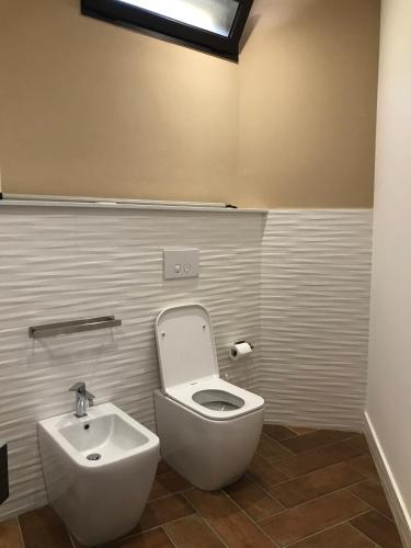 a bathroom with a toilet and a sink at B&B & VITA in Mirto