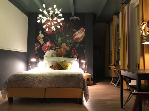 um quarto com uma cama grande e um mural de flores na parede em B&B Logeren bij de burgemeester em Stad aan ʼt Haringvliet