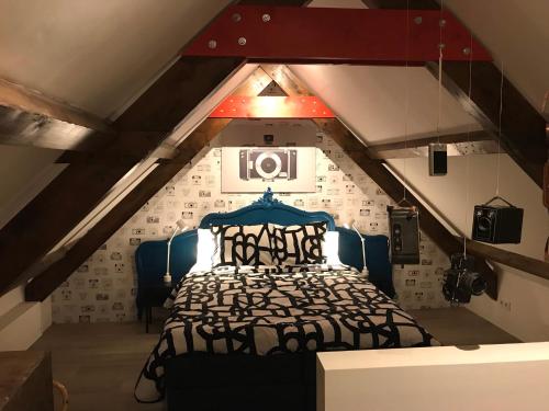 a bedroom with a bed in a attic at B&B Logeren bij de burgemeester in Stad aan ʼt Haringvliet