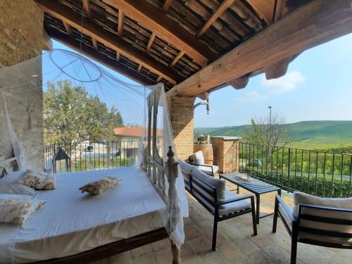 1 dormitorio con 1 cama y sillas en el balcón en Villa Laura, en Castellinaldo