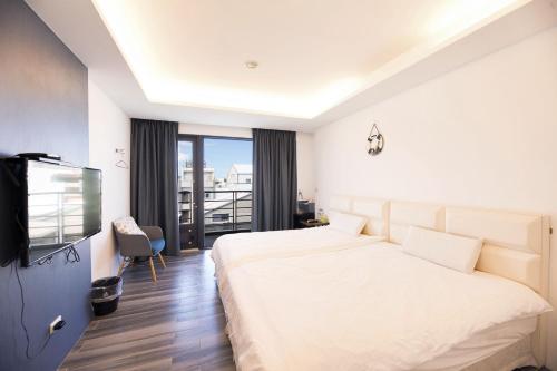 a hotel room with a bed and a balcony at 松柏文旅Cypress Inn in Taitung City
