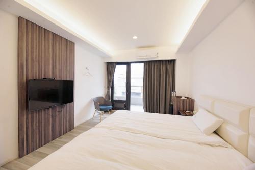 Habitación de hotel con cama y TV de pantalla plana. en 松柏文旅Cypress Inn en Taitung