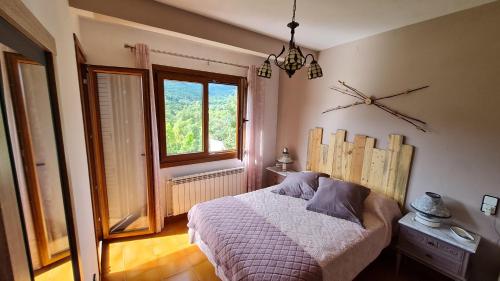 1 dormitorio con cama y ventana en Apartament Vent de Port, en Vilaller
