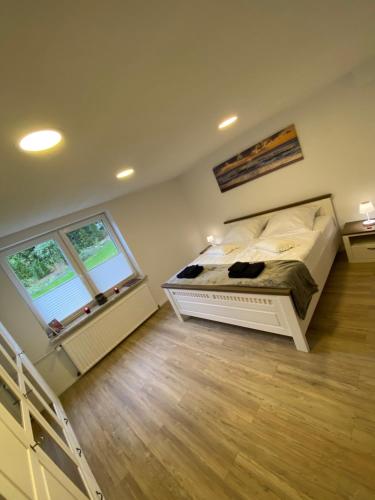 um quarto com uma cama e duas janelas em Schöne Wohnung mit Garten beim Outletcenter 5 km em Boostedt