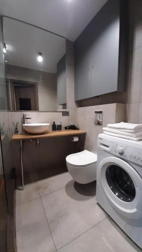 a bathroom with a toilet and a sink and a washing machine at Style Стильні апартаменти в ЖК "Варшавський" біля парку in Ternopilʼ