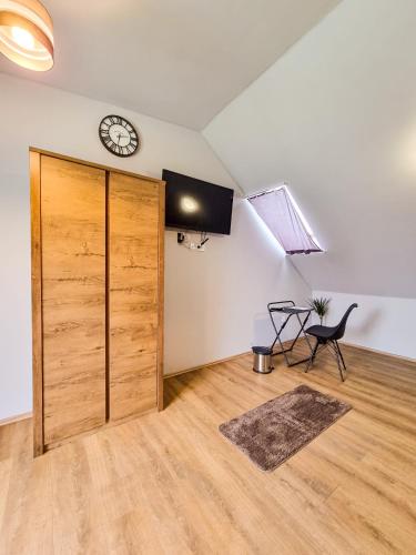 a room with a door and a clock on the wall at XXL Rooms Osijek in Osijek