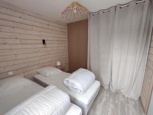 Cette petite chambre comprend 2 lits avec des draps blancs. dans l'établissement Le coin des Sables, à Les Sables-dʼOlonne