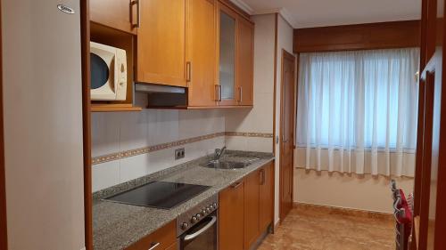 a kitchen with a sink and a microwave at Apartamento in Ferrol