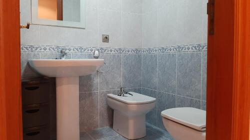 a bathroom with a sink and a toilet at Apartamento in Ferrol