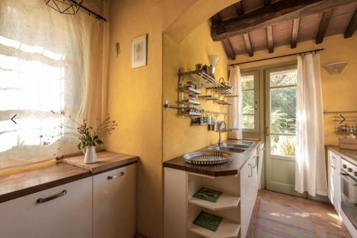 una cucina con lavandino e finestra di Podere San Niccola a Punta Ala