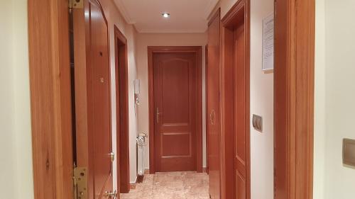 a hallway with a brown door in a room at Apartamento in Ferrol