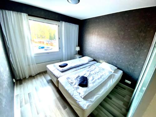 a small bed in a room with a window at DP Apartments Vaasa IV in Vaasa
