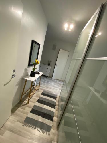 un escalier avec un miroir et une table avec un vase dans l'établissement DP Apartments Vaasa IV, à Vaasa