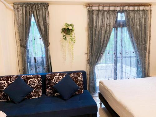 a blue couch in a bedroom with windows at 花蓮小週末包棟民宿 in Hualien City