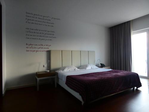 a bedroom with a bed with writing on the wall at Hotel Vila D'Óbidos in Óbidos