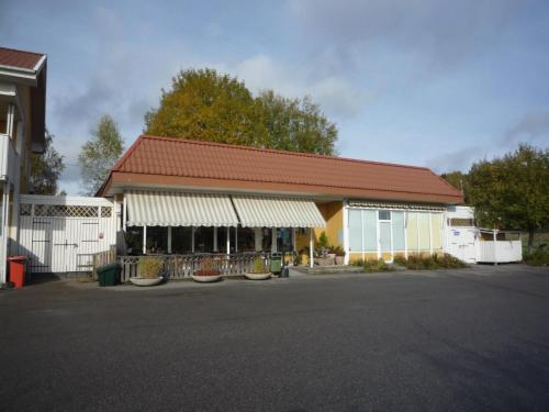 a building with a red roof in a parking lot at Håknäs Vandrarhem in Järna