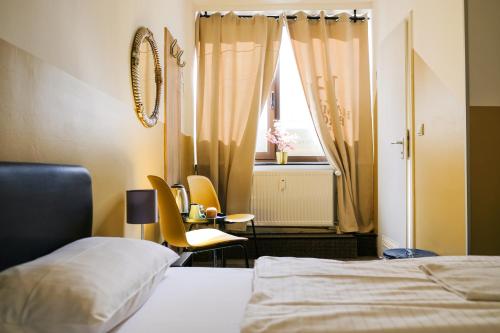 a bedroom with a bed and a table and a window at Hammerbrook Hostel in Hamburg