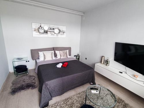 een slaapkamer met een bed en een flatscreen-tv bij Apartment Apex penthouse self check-in in Karlovac