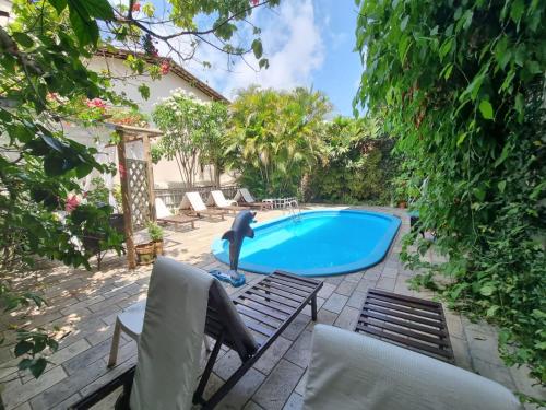 a pool with a dolphin in the middle of a yard at Pousada Beijos y Abraços in Natal