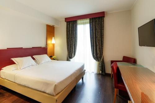 a hotel room with a bed and a window at Red's Redaelli Hotel in Barzanò