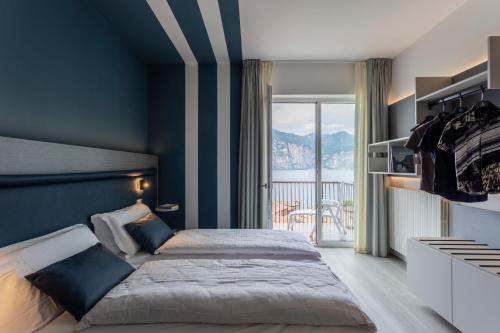 a bedroom with a bed and a large window at Hotel Garni Selene in Malcesine