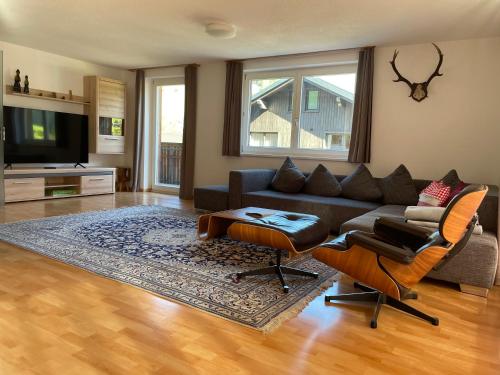 a living room with a couch and chairs and a television at Monika-Mellau Appartements in Mellau