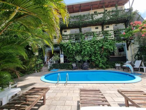 a swimming pool in front of a building at Pousada Beijos y Abraços in Natal