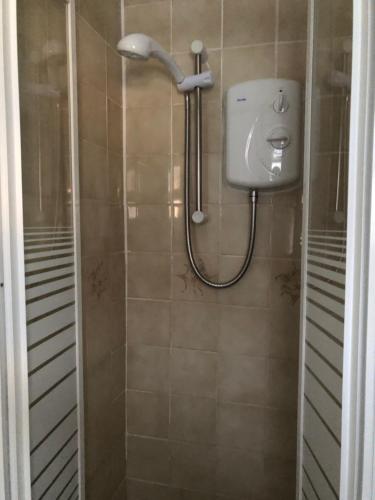 een douche met een douchekop in de badkamer bij Melrose Hotel in Blackpool