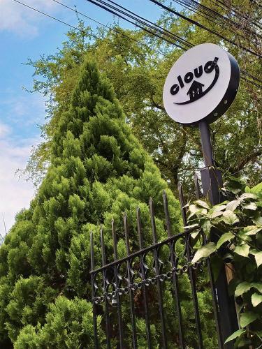 a sign on a fence next to a tree at Cloud9 Hostel in Medellín