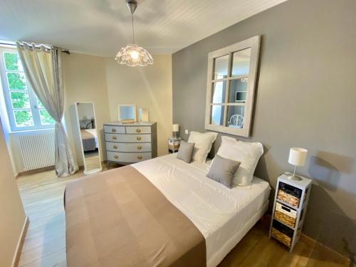 um quarto com uma cama, uma cómoda e uma janela em L'Antre des Bastides em Saint-Martin-de-Villeréal