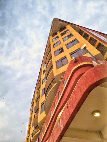 a tall yellow building with windows on top of it at LEYSHOF HOTEL in Mwanza